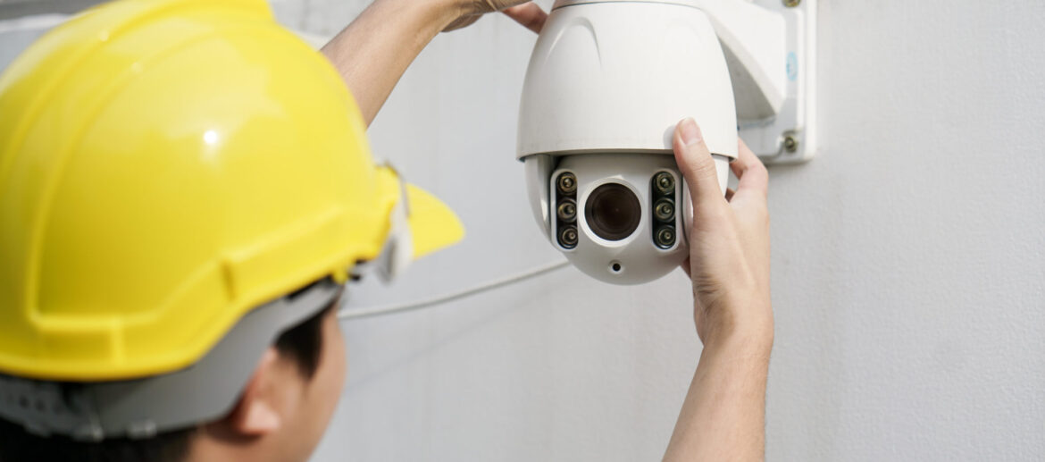 Close Up Of Male Technician Fixing CCTV Camera On Wall Close Up Of Male Technician Fixing CCTV Camera On Wall